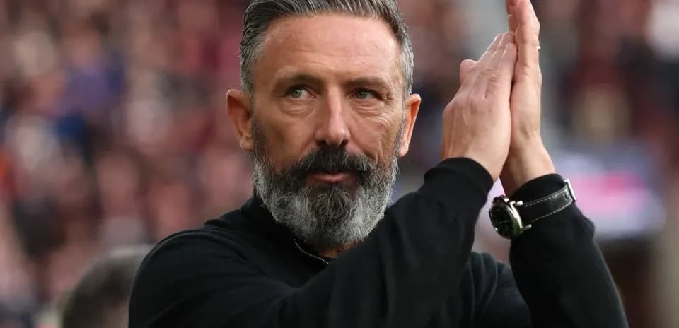 Entrenador aplaudiendo en el banquillo durante el partido
