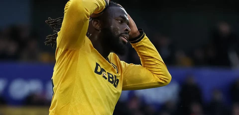 Jugador de fútbol con camiseta amarilla expresando frustración