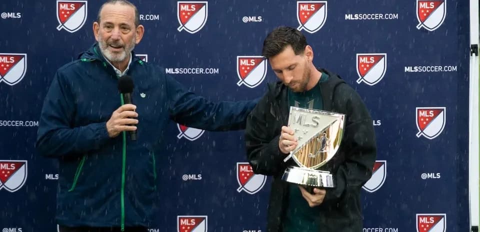 Lionel Messi recibiendo un trofeo durante evento lluvioso