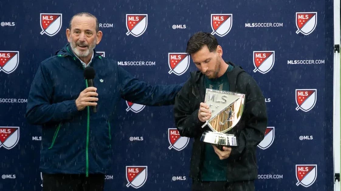 Lionel Messi recibiendo un trofeo durante evento lluvioso
