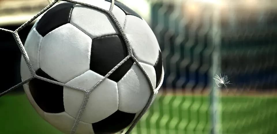 Balón de fútbol en la red de la portería