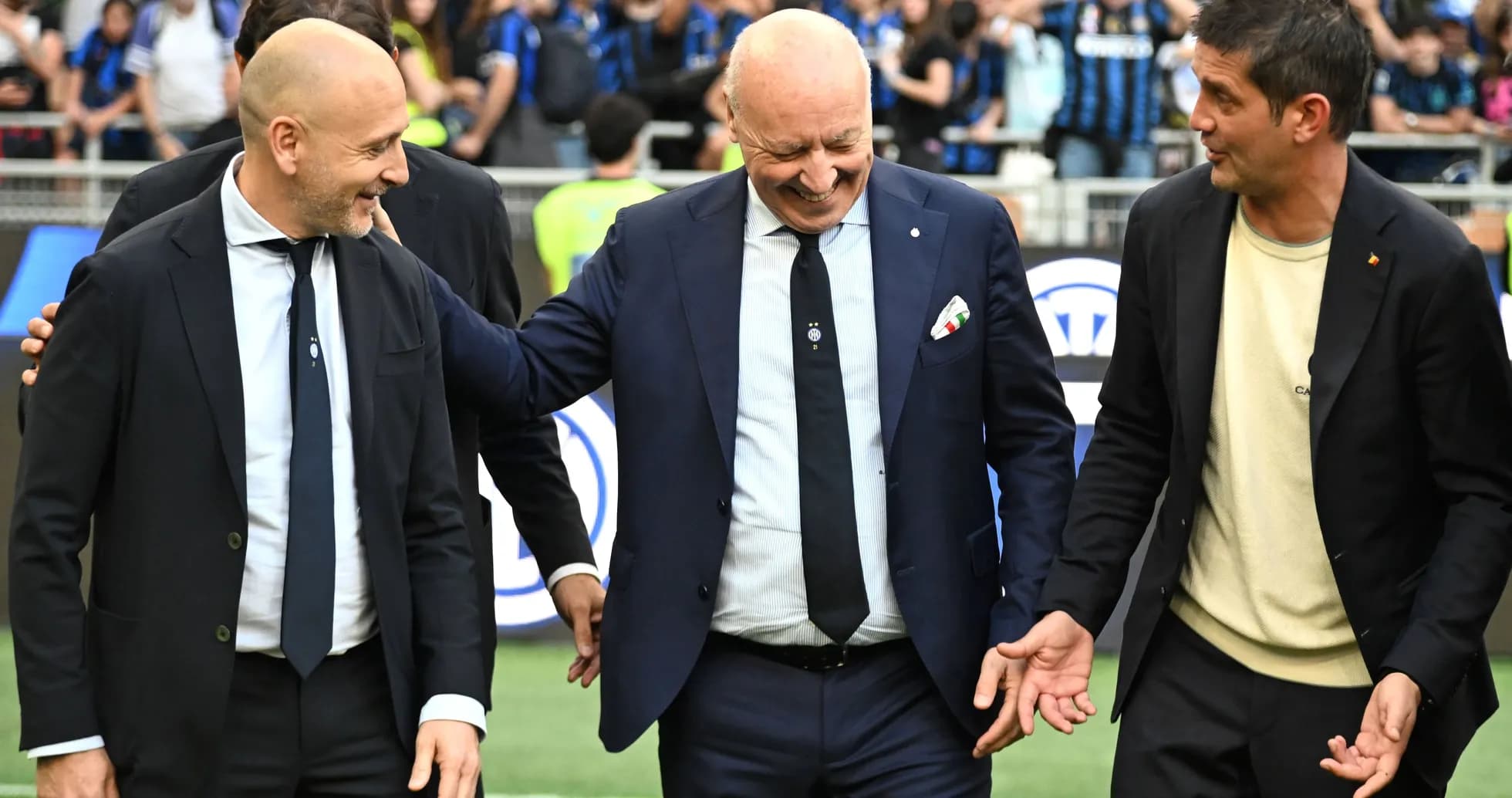 Tres entrenadores conversando en el campo de juego