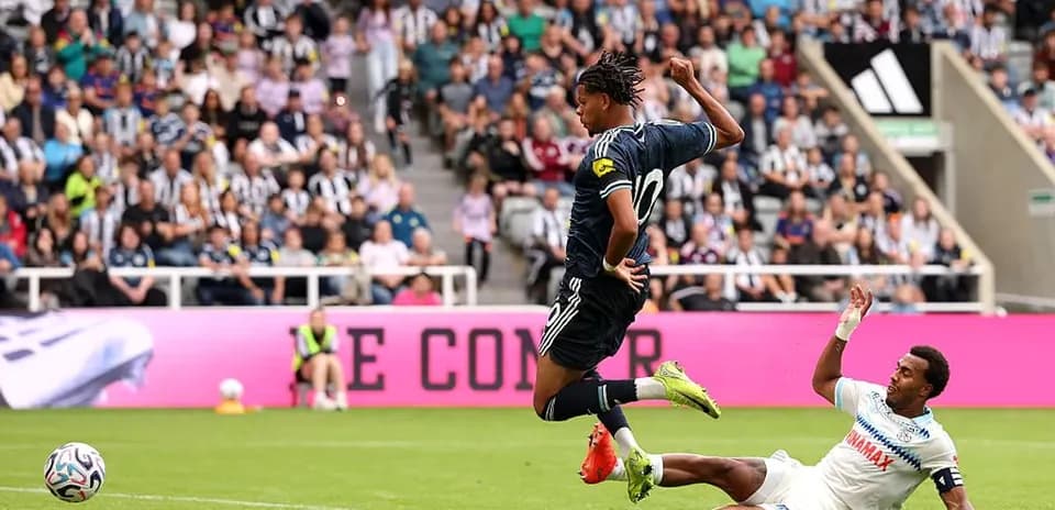 Jugador saltando sobre oponente en partido de fútbol
