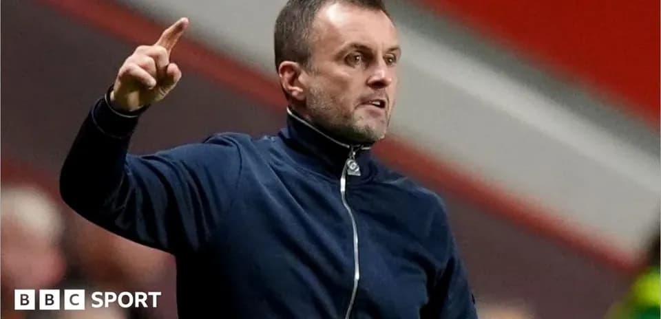 Entrenador dando instrucciones desde la banda del campo
