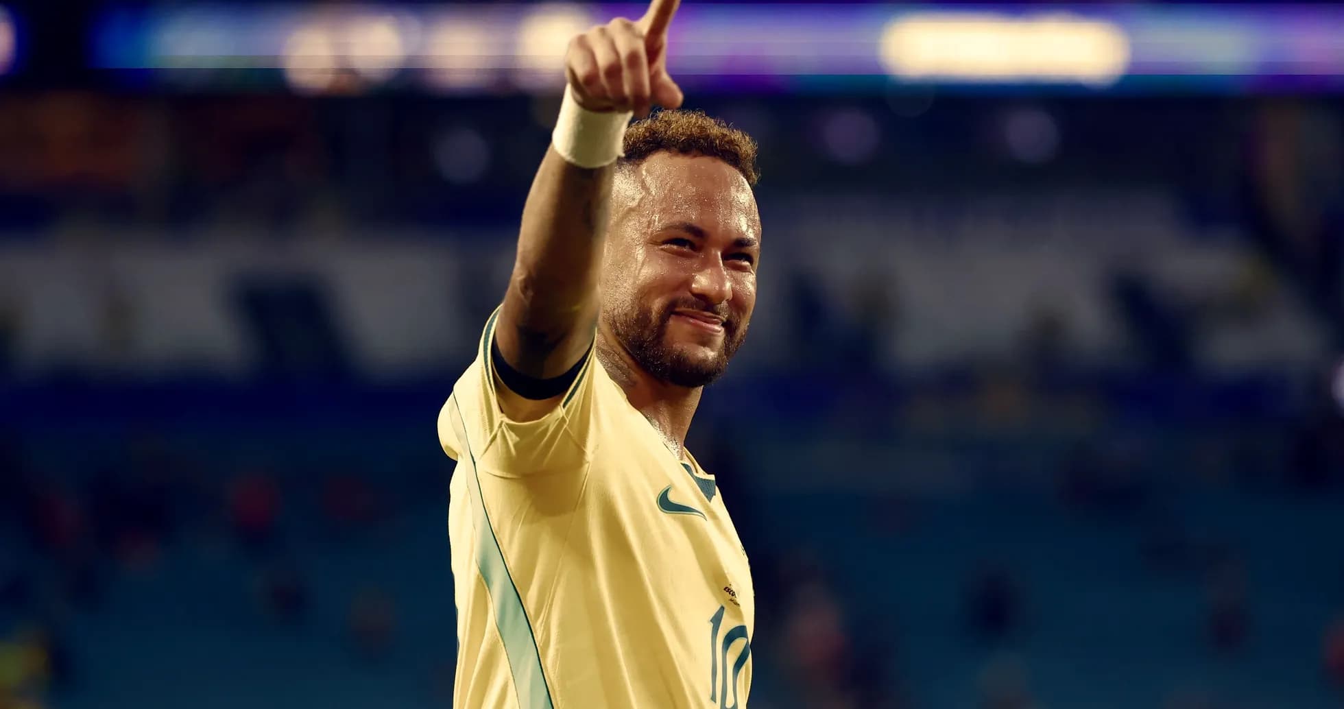 Jugador de fútbol señalando hacia arriba tras partido