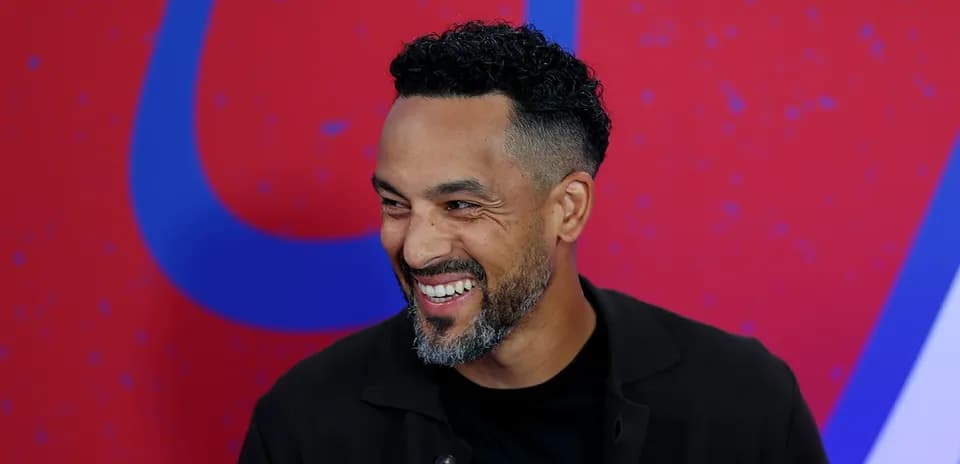 Hombre sonriendo en una conferencia de prensa
