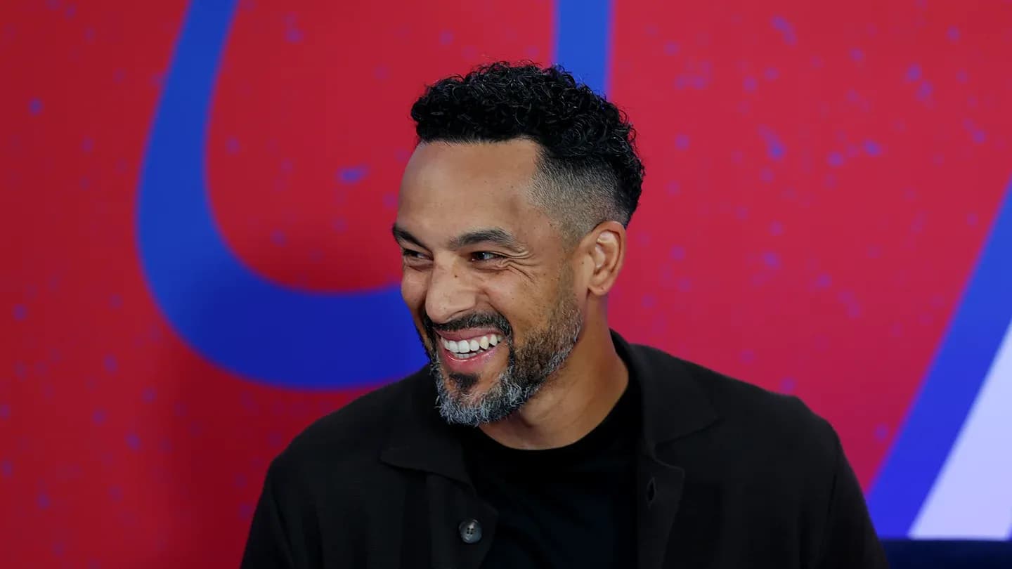 Hombre sonriendo en una conferencia de prensa