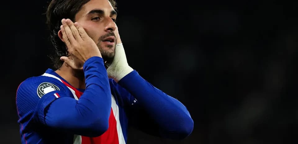 Jugador con camiseta azul sosteniendo la cabeza en gesto de frustración