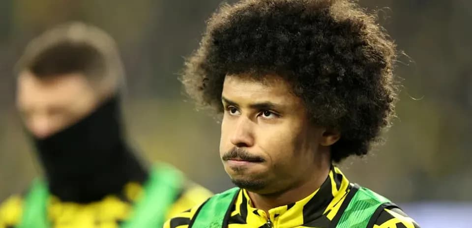Jugador en el banquillo con uniforme de calentamiento