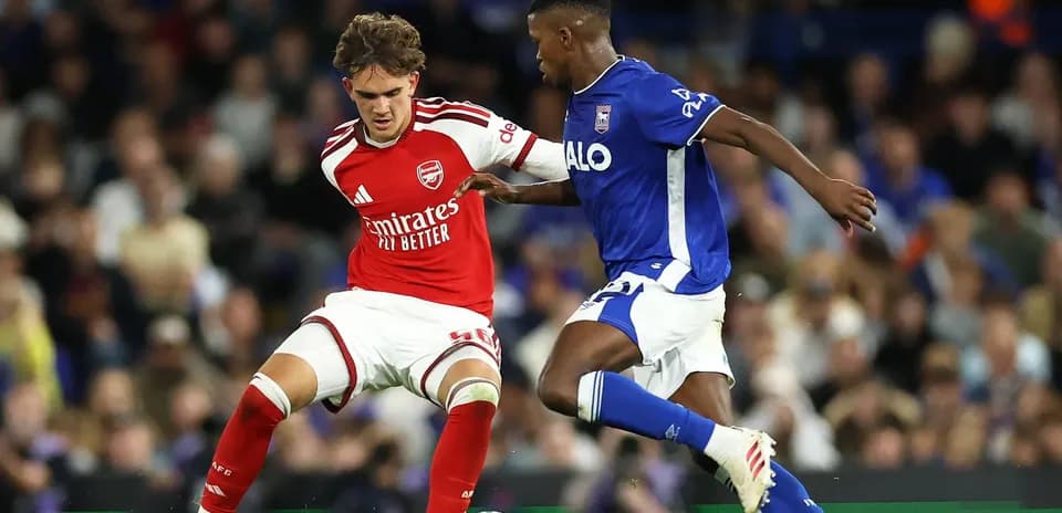 Jugador de Arsenal y jugador de Ipswich compiten por el balón