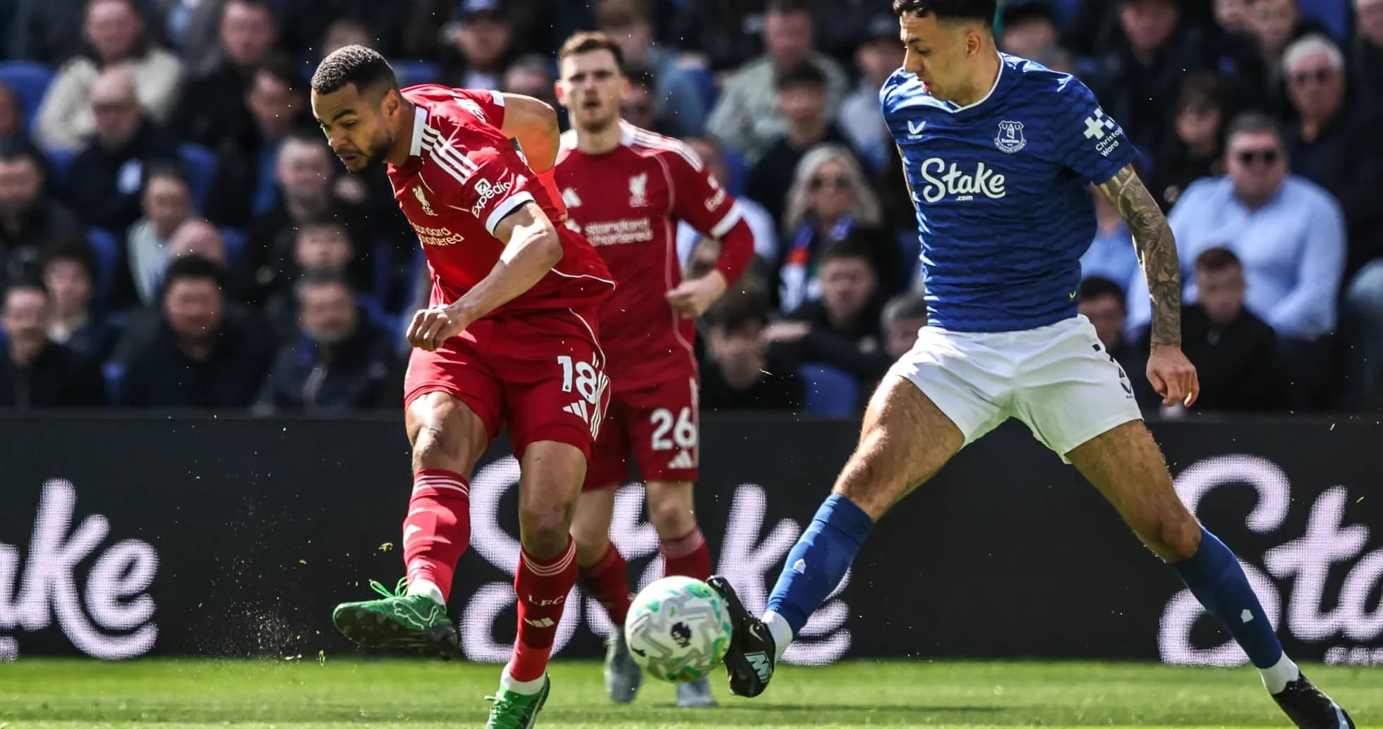 Jugador de Liverpool driblando mientras es marcado por rival