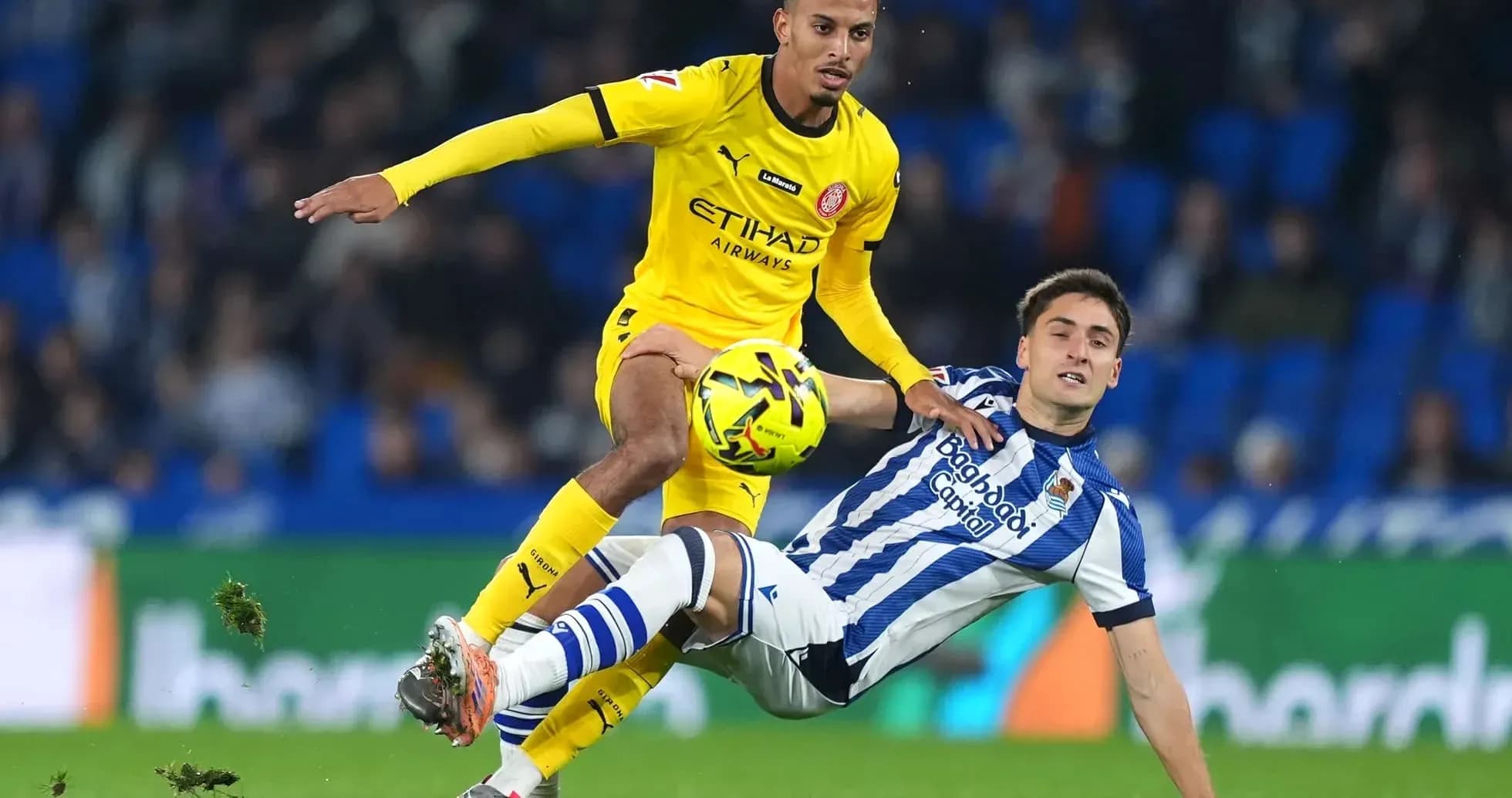 Jugador de Girona desafiando a un rival de Real Sociedad