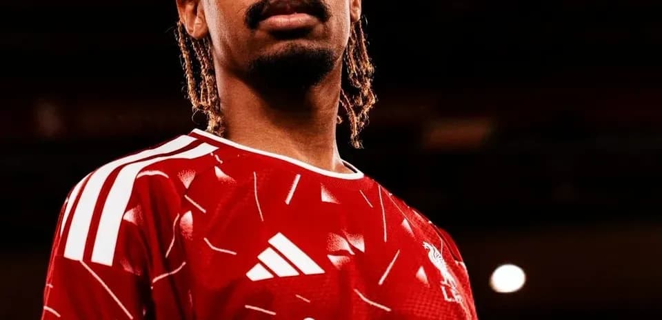 Jugador posando con camiseta roja de Liverpool