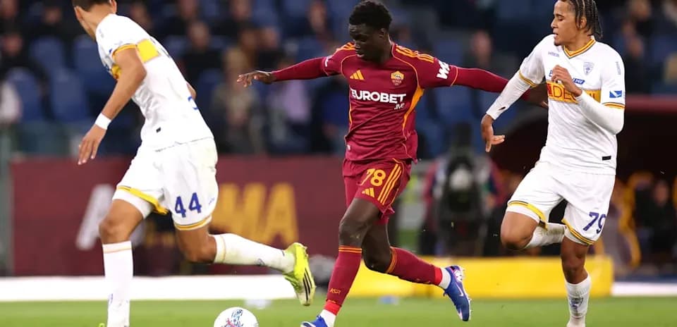 Jugador de Roma driblando entre dos oponentes