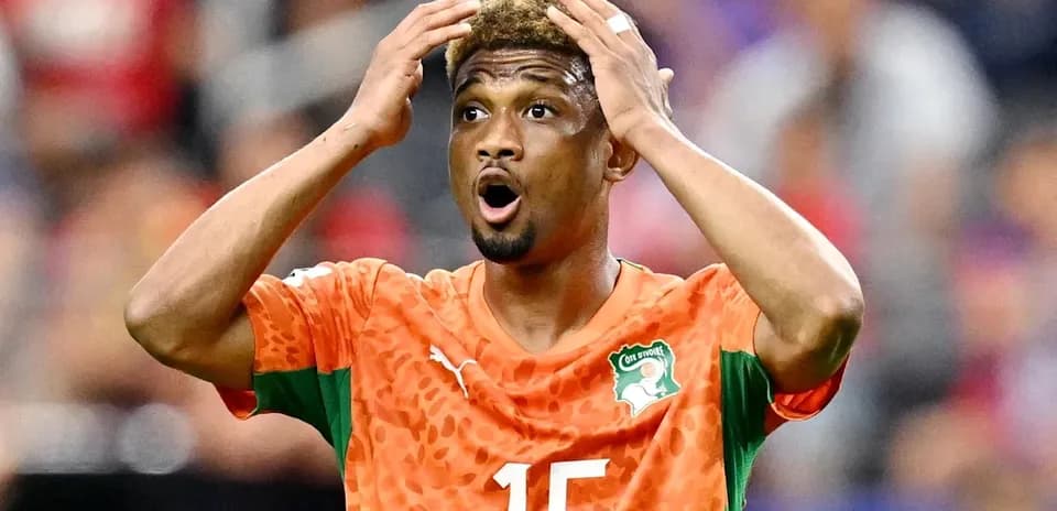 Jugador de Costa de Marfil con camiseta naranja reaccionando