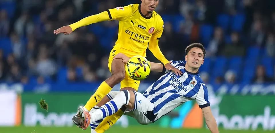 Jugador de Girona desafiando a jugador de Real Sociedad