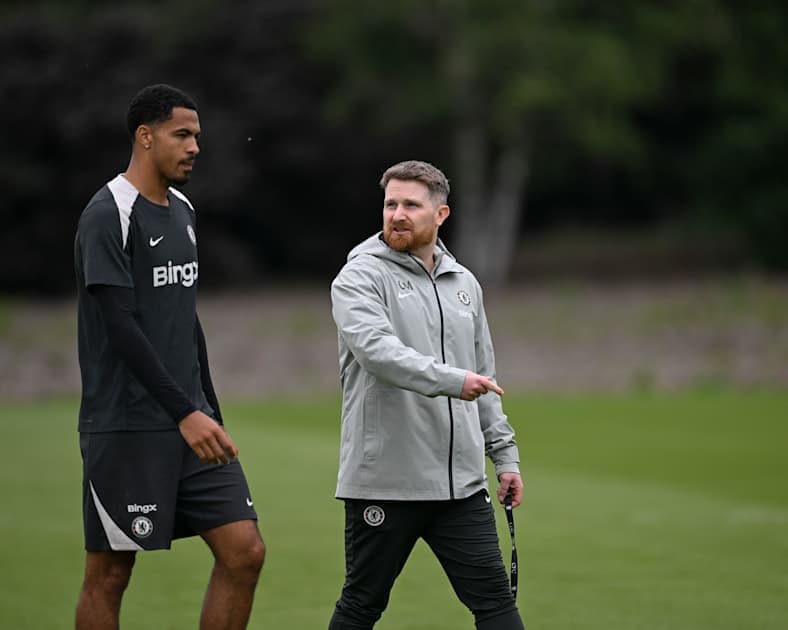 Jugador y entrenador conversando en el campo de entrenamiento