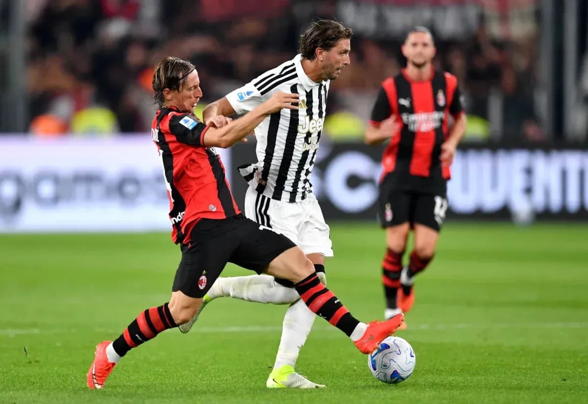 Jugador de AC Milan intentando quitar el balón a jugador de Juventus