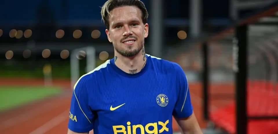Jugador sonriente con camiseta del Chelsea en campo