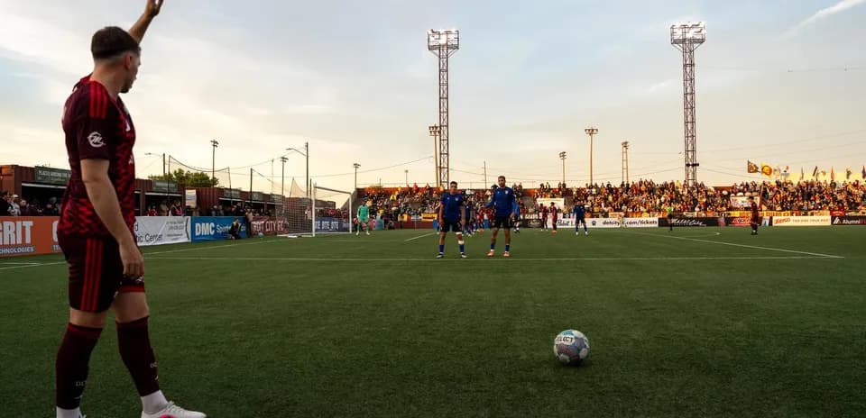 Jugador señalando la jugada en partido de fútbol