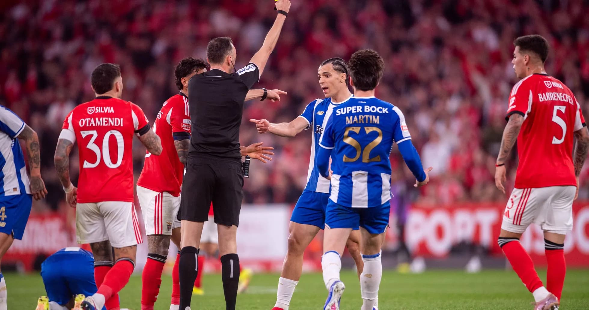 Árbitro mostrando tarjeta amarilla en partido de fútbol