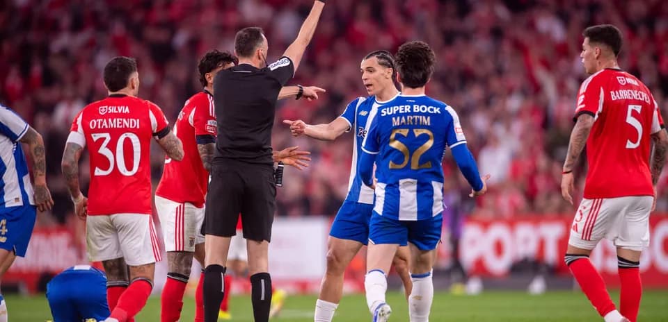 Árbitro mostrando tarjeta amarilla en partido de fútbol