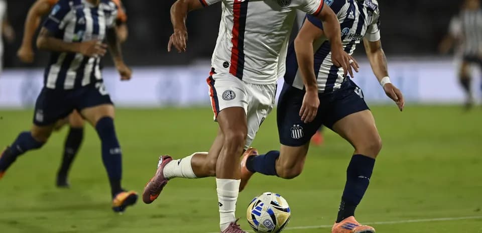 Jugador de San Lorenzo driblando a rival de Talleres