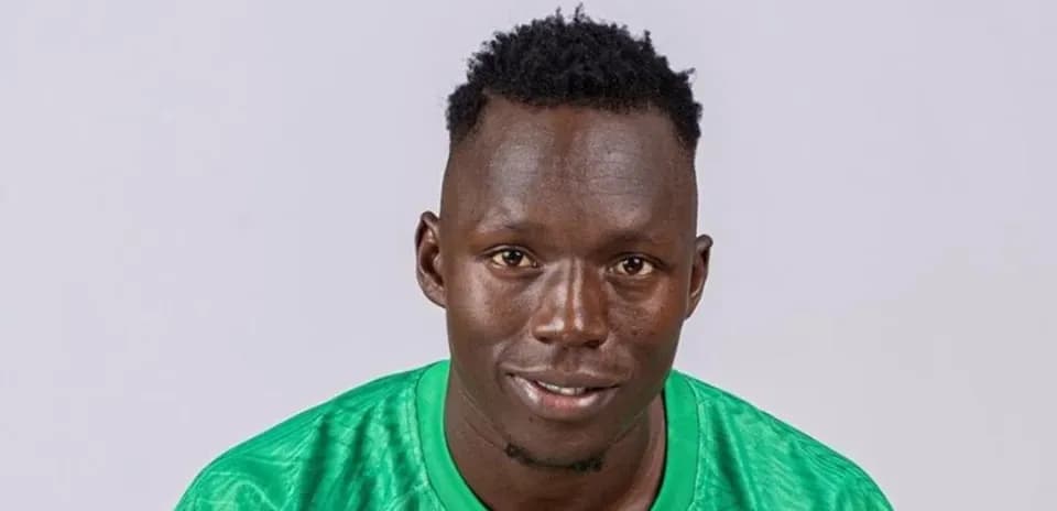 Jugador de fútbol posando con camiseta verde