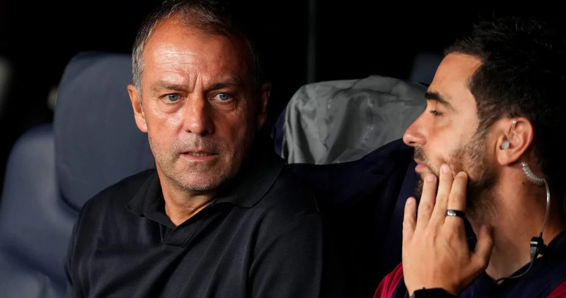 Entrenadores conversando en el banquillo durante el partido