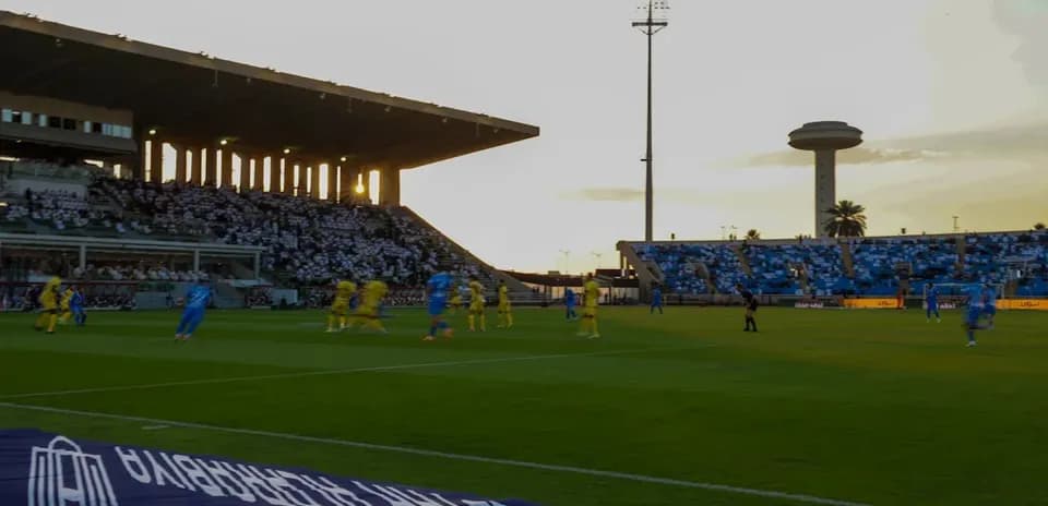 Partido de fútbol en estadio con espectadores
