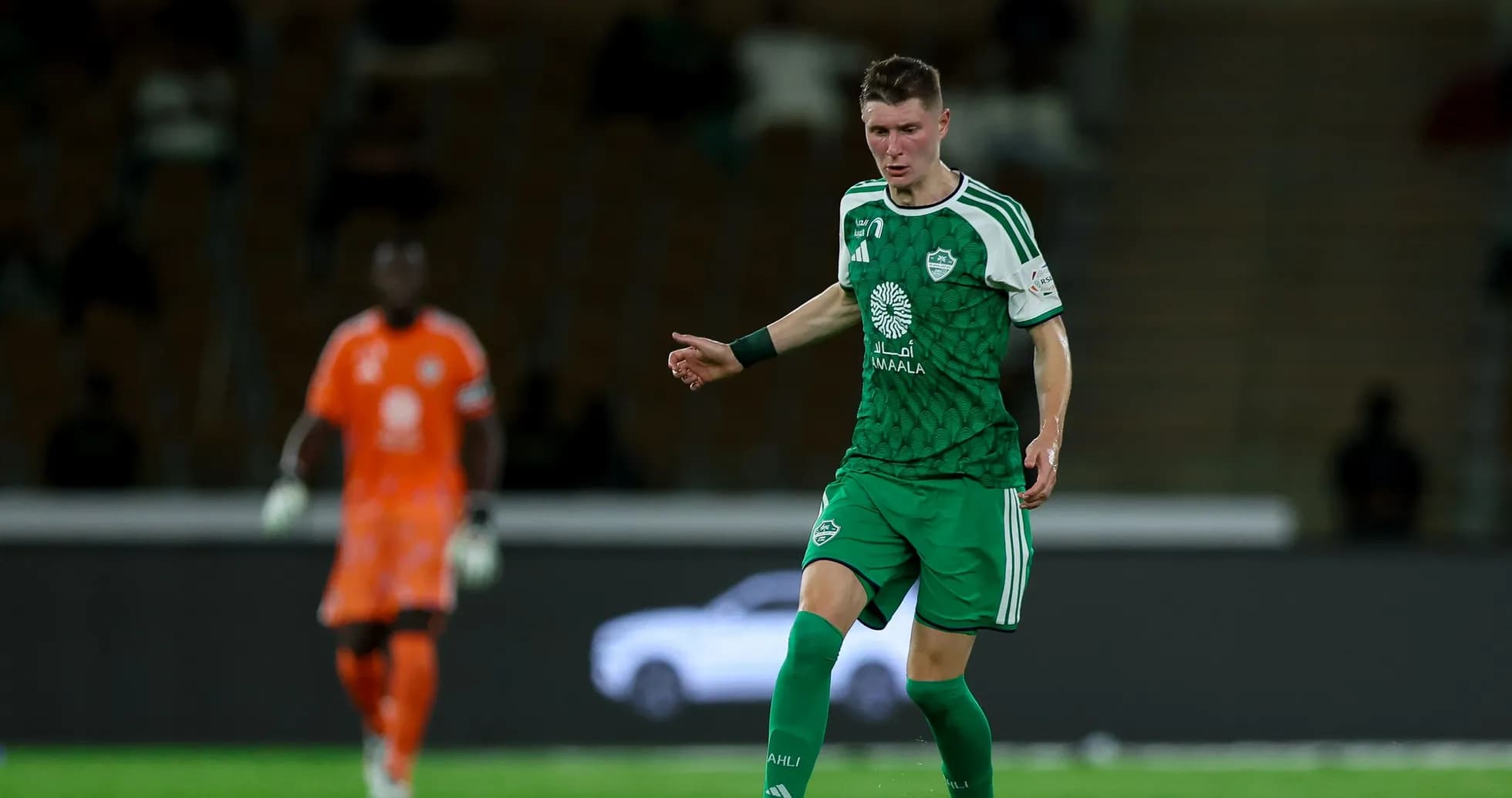 Jugador con uniforme verde en acción durante partido