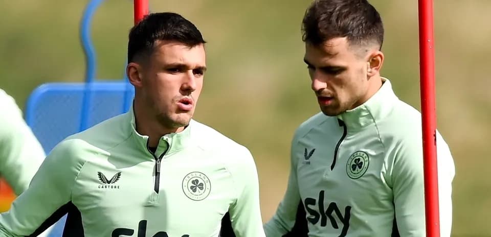 Dos jugadores conversando durante entrenamiento en campo