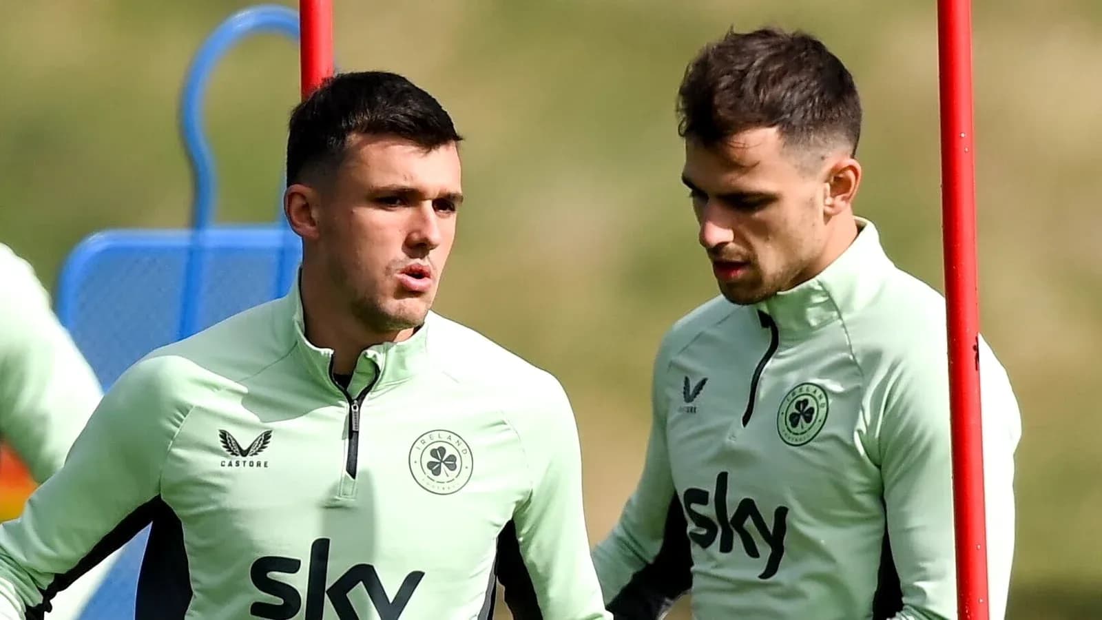 Dos jugadores conversando durante entrenamiento en campo