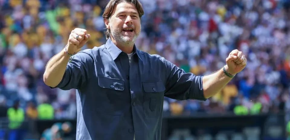 Entrenador celebrando en el campo durante un partido