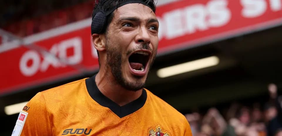 Jugador celebrando con camiseta naranja en estadio