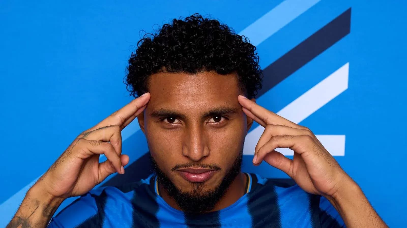 Jugador posando con fondo azul en camiseta azul