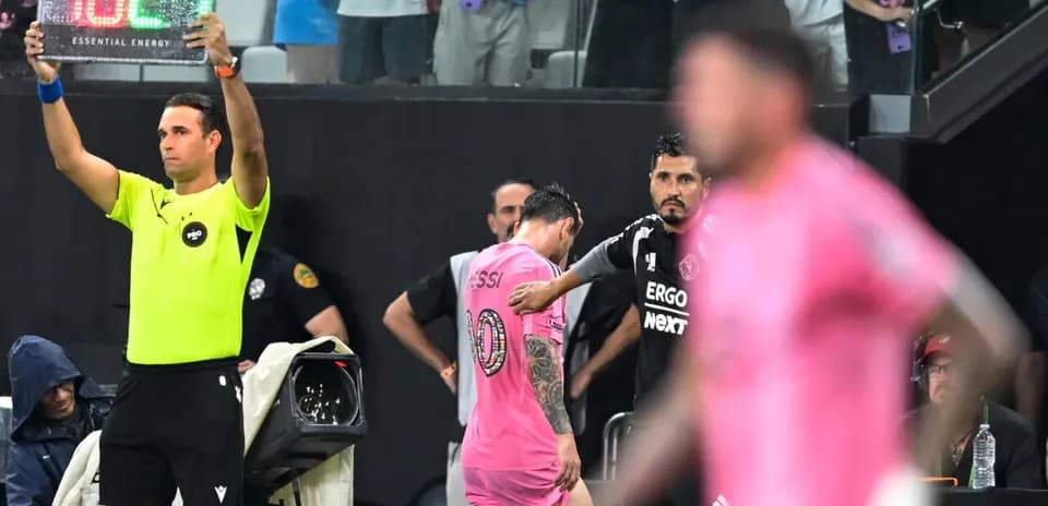 Jugador saliendo del campo, entrenador observa desde la línea