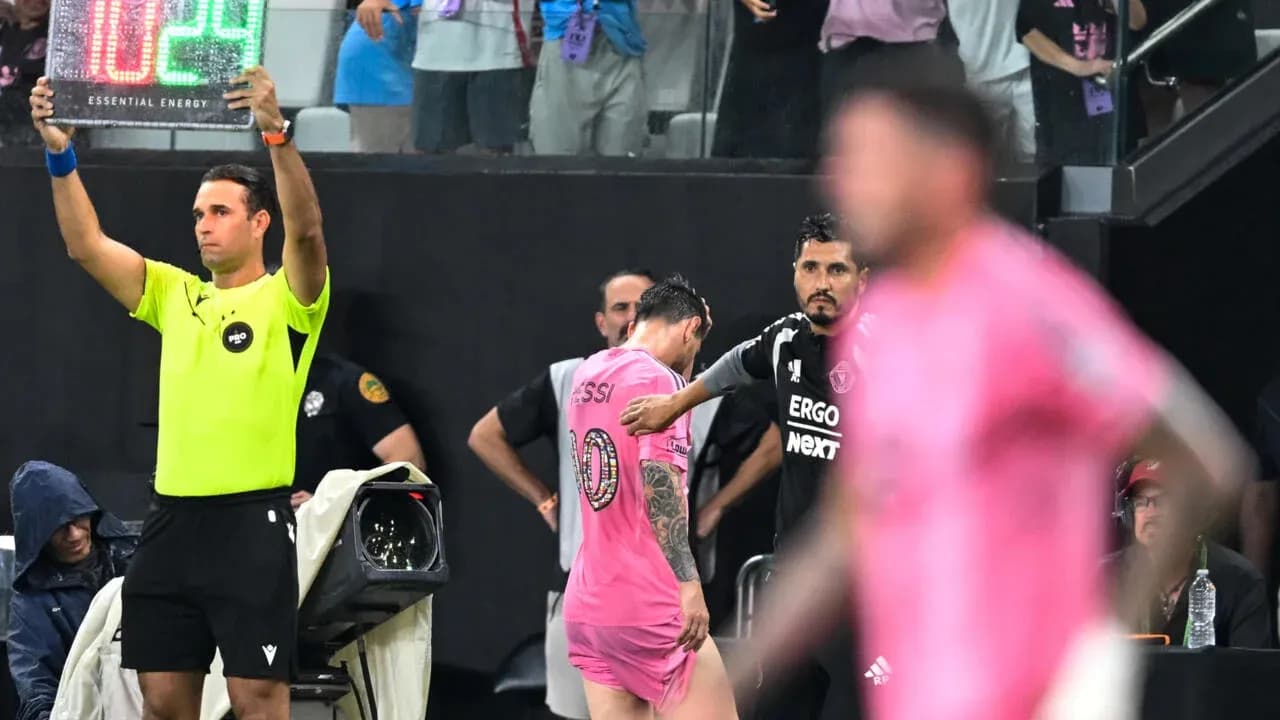 Jugador saliendo del campo, entrenador observa desde la línea