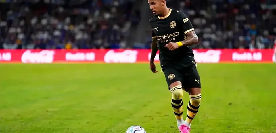 Jugador corriendo con balón en campo de fútbol