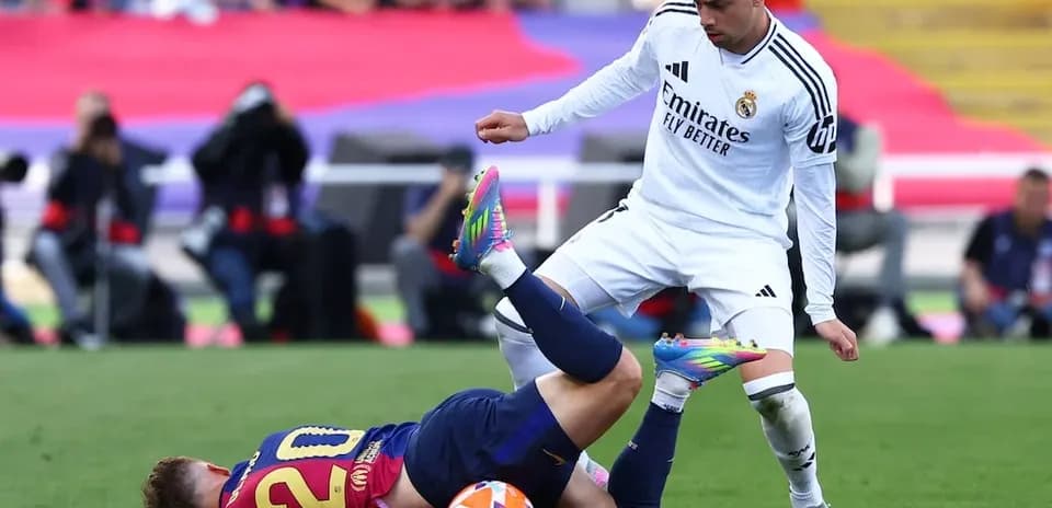 Un jugador de Barcelona cae ante un rival del Madrid