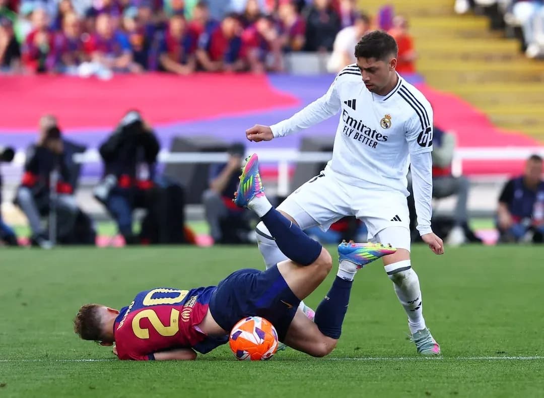 Un jugador de Barcelona cae ante un rival del Madrid