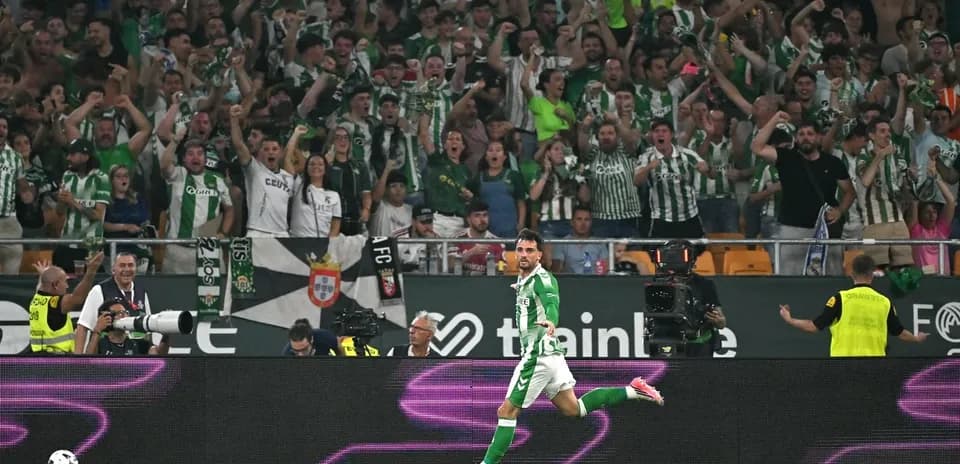 Jugador celebrando un gol frente a aficionados entusiastas