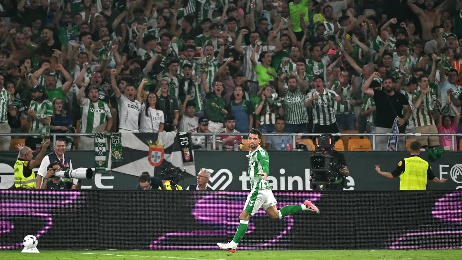 Jugador celebrando un gol frente a aficionados entusiastas