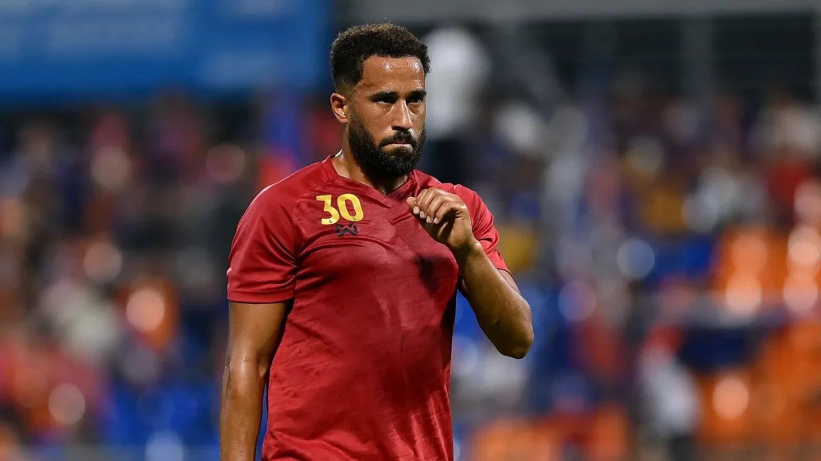 Jugador con camiseta roja en el campo de fútbol