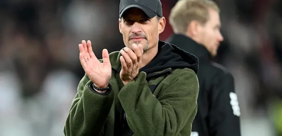 Entrenador aplaudiendo en el estadio durante partido