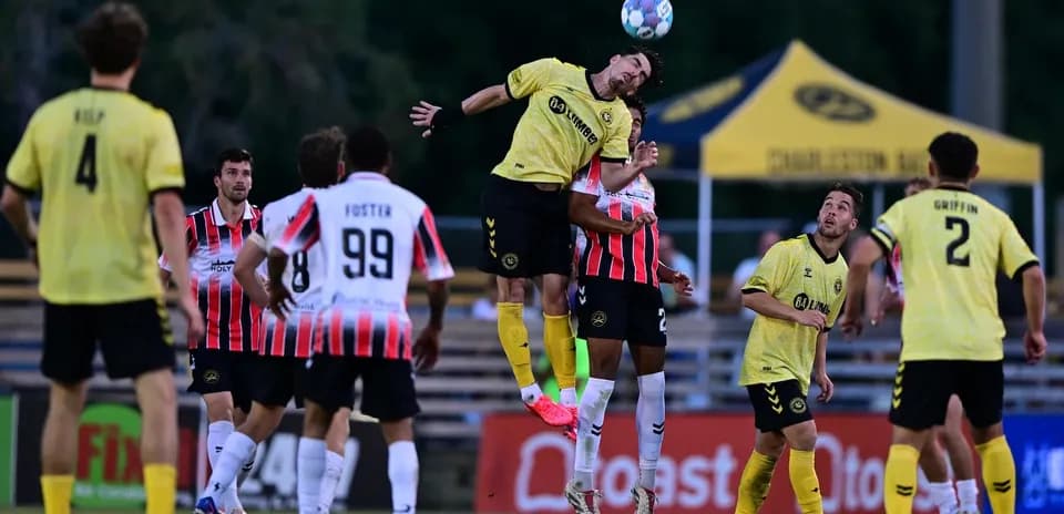 Jugador salta para cabecear el balón en el partido