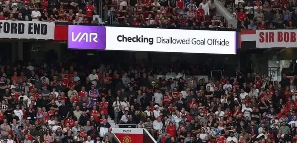 A crowd watching VAR review disallowed goal sign