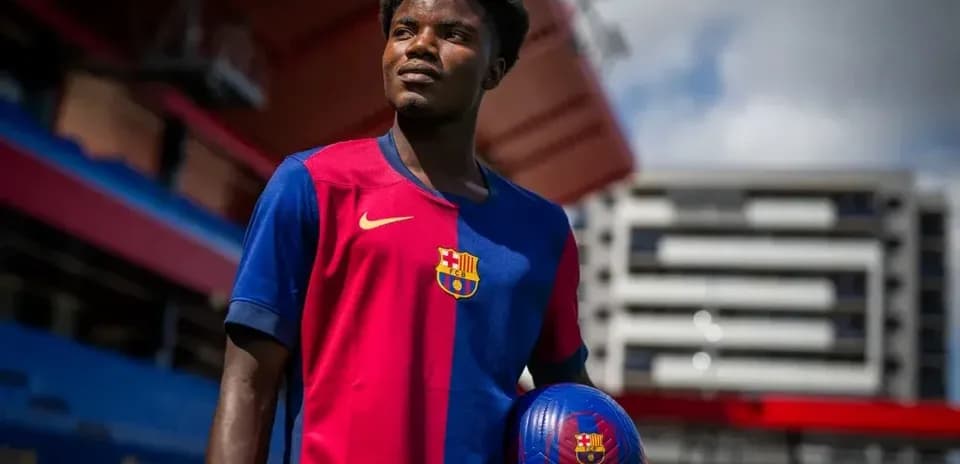 Jugador sosteniendo balón en camiseta del Barcelona