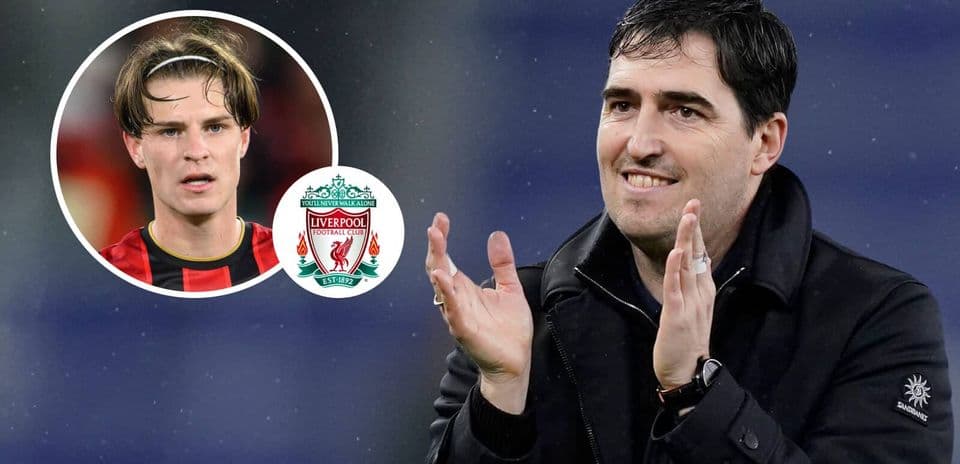 Entrenador aplaudiendo con jugador y escudo de Liverpool