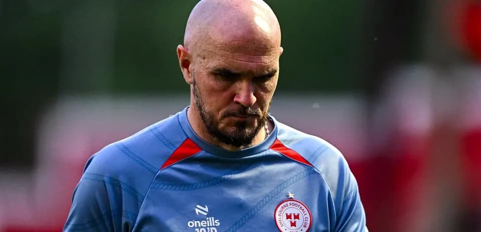 Jugador de fútbol con camiseta de entrenamiento mirando hacia abajo